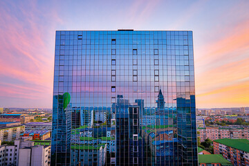 Contemporary Architecture and Urban Reflection Awe Inspiring High Rise Glass Building Mirroring the Cityscape and a Vibrant Sky at Sunset