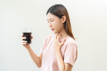 Acid reflux disease, suffer asian young woman, girl hand holding a glass of cola, have symptom...