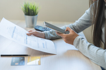 Bill pay concept. Online internet banking asian young man hand holding invoice use mobile smart phone spend scan barcode to transfer to pay money of credit card without cash. Technology of financial.