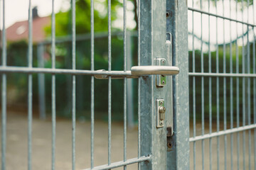 This is a CloseUp Image Featuring a Silver Metal Gate That Includes a Lock and Latch Mechanism,...