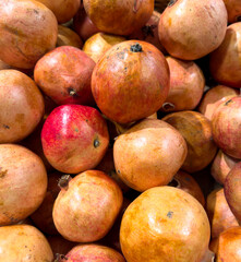 A pile of fruit with a few apples and pomegranates