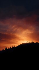 Obraz premium Crosses silhouetted against a dramatic mountain sunset