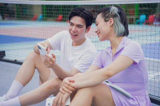 Friends enjoying a break while playing pickleball at a vibrant outdoor court in the afternoon
