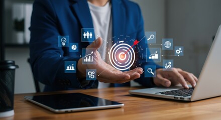Targeted Strategy: Holographic Icons over Hand, Laptop & Tablet on Desk