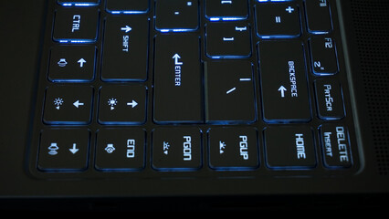 Close up side view of backlit computer laptop keyboard isolated