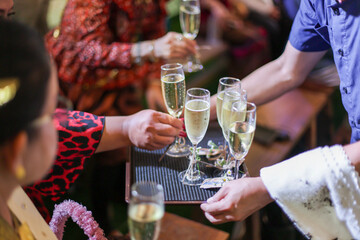 selective focus Champagne Glasses on a tray, serving alcoholic beverages, welcome drinks to guests at a celebration, at a wedding
