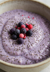 Chia seed pudding with fresh berries in a ceramic bowl.
