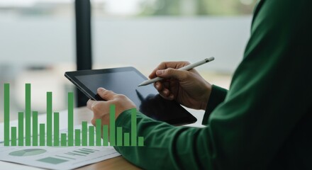 Tablet stylus data analysis, green chart overlay, business person at desk.