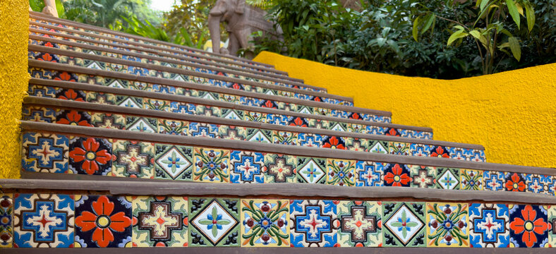 Vibrant Tiled Staircase with Artistic Patterns in a Lush Garden Setting
