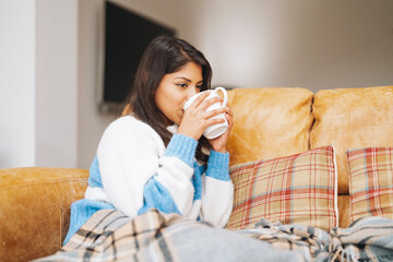 Cozy afternoon at home with warm drink and soft blanket in a modern living room