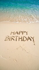 Fototapeta premium Beach Sand Written 'Happy Birthday' with Slow Waves 