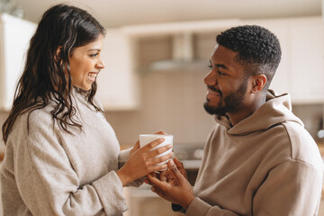 Couple enjoying a warm drink together in a cozy kitchen during a relaxed afternoon at home