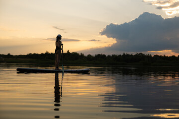 Paddleboarding at Sunset on a Tranquil Lake