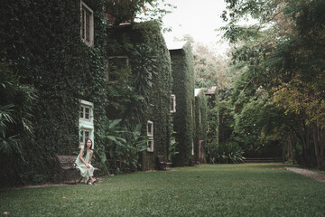 Teenage girl in lush greenery at an enchanted house nature scene tranquil atmosphere