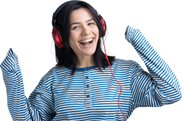 A young girl in a striped vest is listening to music in red headphones in a studio and dancing.