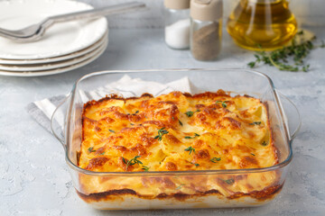 Potato gratin - graten (baked potatoes with cream and cheese) with rosemary and forks (Turkish name; Kremali patates)