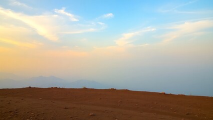 Naklejka premium Serene sunset landscape with red sand dunes and distant mountains