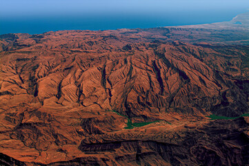 Aerial view of rugged mountain landscape and coastline in Oman
