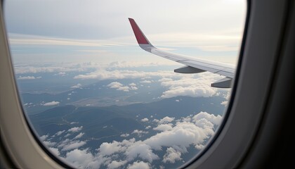Obraz premium View of Airplane Wing Above Clouds with Scenic Landscape Below