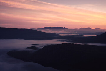 Morning light illuminating the vast and wild north of scotland with clouds creeping in between the hills