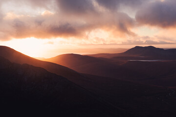 Sunset light illuminating layers of mountains in Scotland