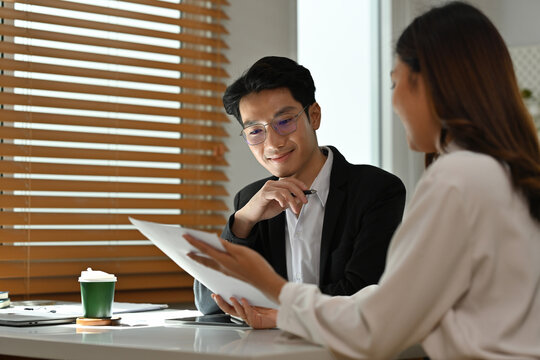 Two Business Analysts Discussing Reports in the Office, Business Collaboration, and Data Review