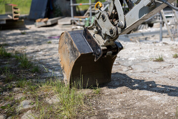 Close-up of excavator bucket digging dry soil. Heavy machinery detail at work on a construction...
