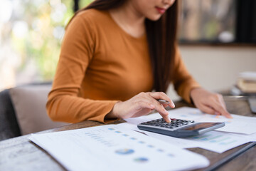 Deduction planning, debt asian young woman  hand using calculator to calculating  money balance from bill and income, cost budget expenses for pay money form personal individual on table at home.