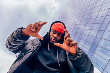 Content creator framing the shot with his hands in front of modern building
