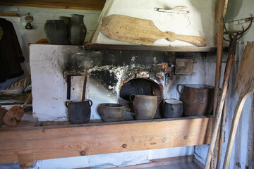 A wood stove with a wooden handle and a wooden spoon leaning against it
