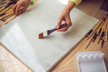 Creative woman painting on canvas in a bright art studio. Concept of artistic inspiration, creativity, and mindful self-expression. 