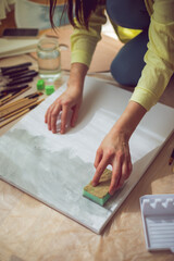 Creative woman painting on canvas in a bright art studio. Concept of artistic inspiration, creativity, and mindful self-expression. 