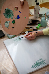 Creative woman painting on canvas in a bright art studio. Concept of artistic inspiration,...