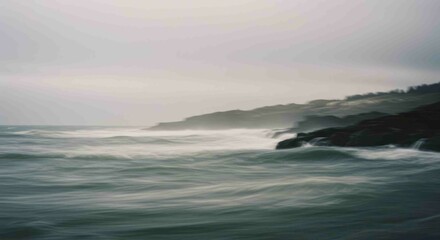 Fototapeta premium Misty Coastal Waves Crashing on Dark Rocks.