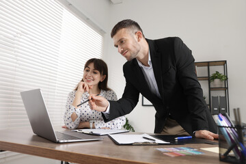 Consultant working with client at table in office, low angle view. Business meeting