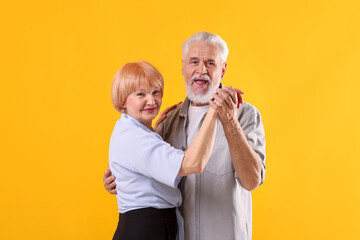 Lovely senior couple together on yellow background