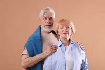 Lovely senior couple together on light brown background