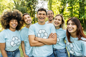 Multi ethnic group of volunteers cleaning up a forest together - Happy team of environmental activists smiling together outdoors - Environmental protection and non profits organization concept