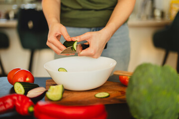 Woman cutting fresh vegetables in the kitchen. Healthy cooking, food preparation and lifestyle concept
