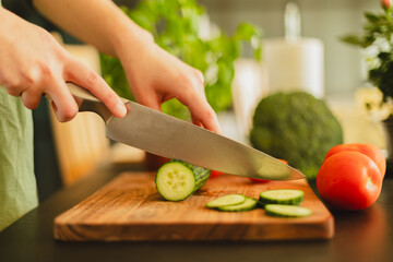 Woman cutting fresh vegetables in the kitchen. Healthy cooking, food preparation and lifestyle concept
