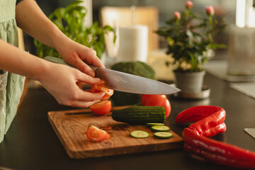 Woman cutting fresh vegetables in the kitchen. Healthy cooking, food preparation and lifestyle...