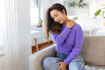 Asian woman suffering from backache and shoulder pain at home. Lower Back Pain . Woman feels back...