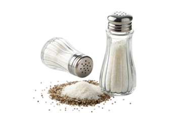 A still life of two salt shakers with salt spilled on a black background in a studio setting
