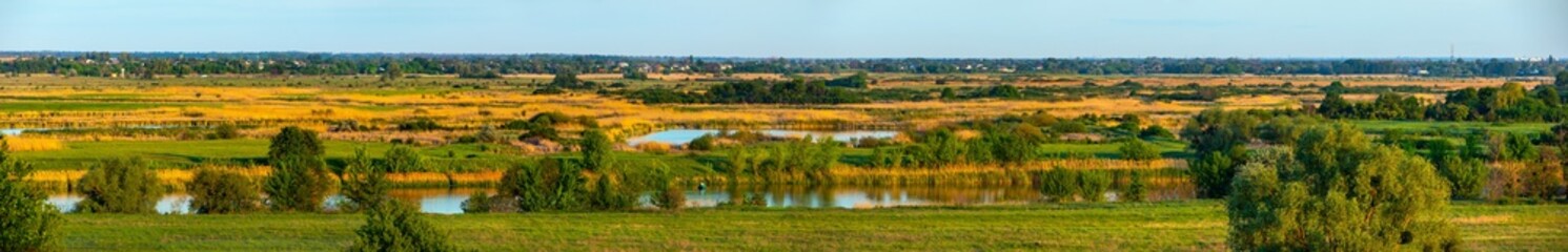 Scenic river valley with trees, bushes and green grass on the meadow. Countryside landscape forest-steppe nature in Ukraine. Panoramic view © Vlad Kazhan