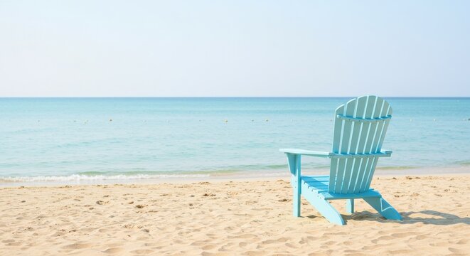 Light blue beach chair on sandy shore by tranquil turquoise ocean water and clear sky, peaceful seaside relaxation scene.