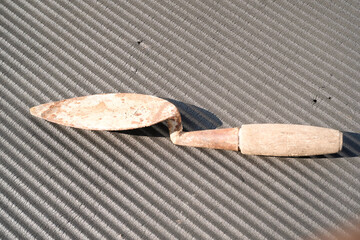 A rusty trowel with a wooden handle isolated on black backgrounds. Hand shovel used for planting...