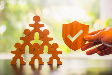 Shield icon and people model. Security protection and group  insurance. The concept of family home, protection, health care day, car insurance.