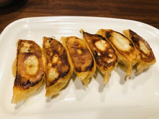 白い皿に乗せられた焼きたての餃子6個