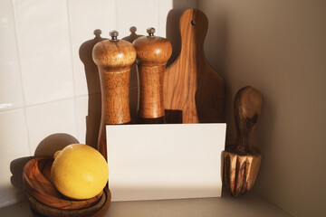 Wooden olive kitchen utensils with paper blank for menu and recipe. Modern culinary mockup for cooking healthy food.