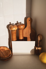 Wooden olive kitchen utensils with paper blank for menu and recipe. Modern culinary mockup for cooking healthy food.